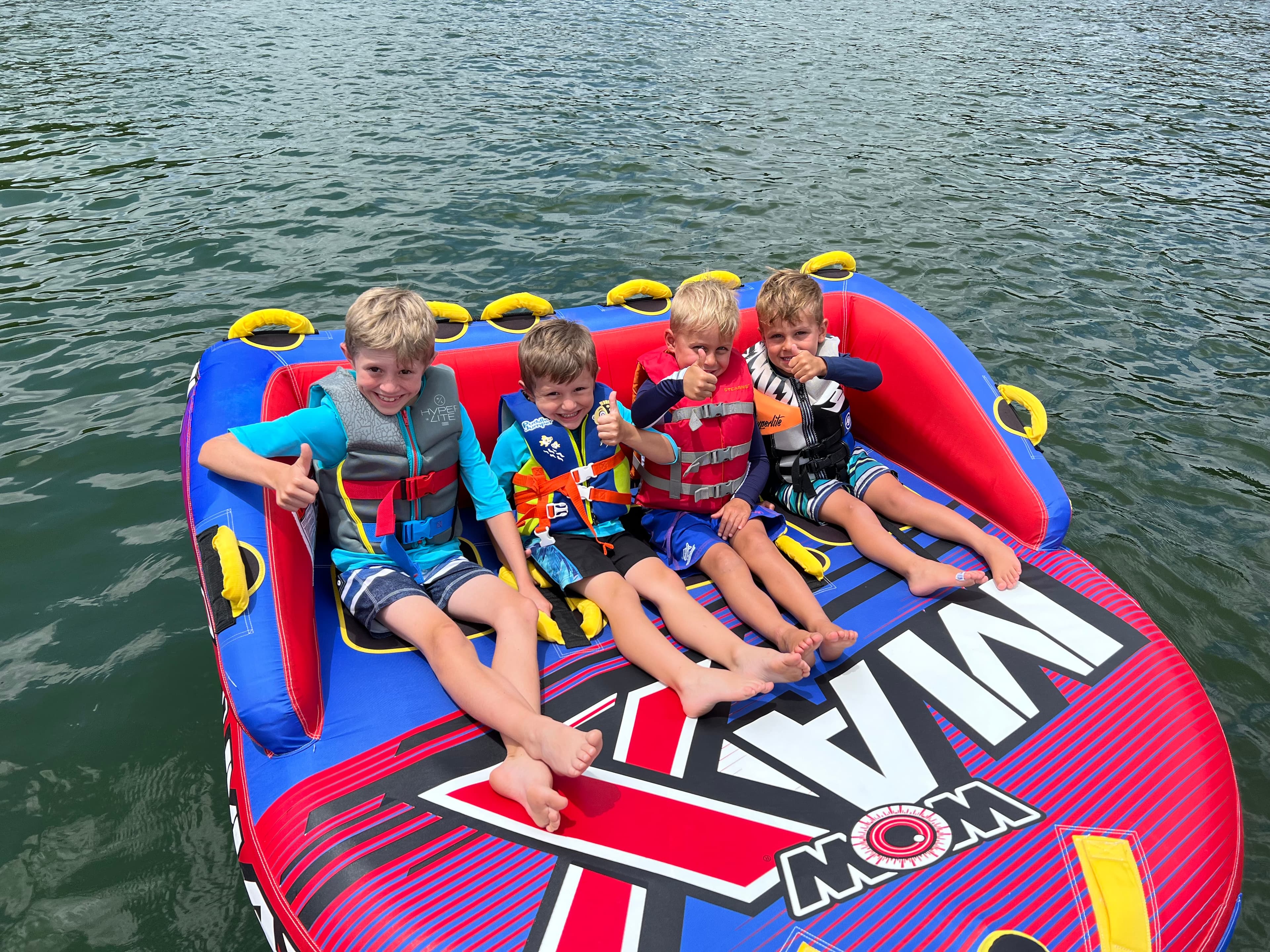 Kids sitting on a tube on the lake