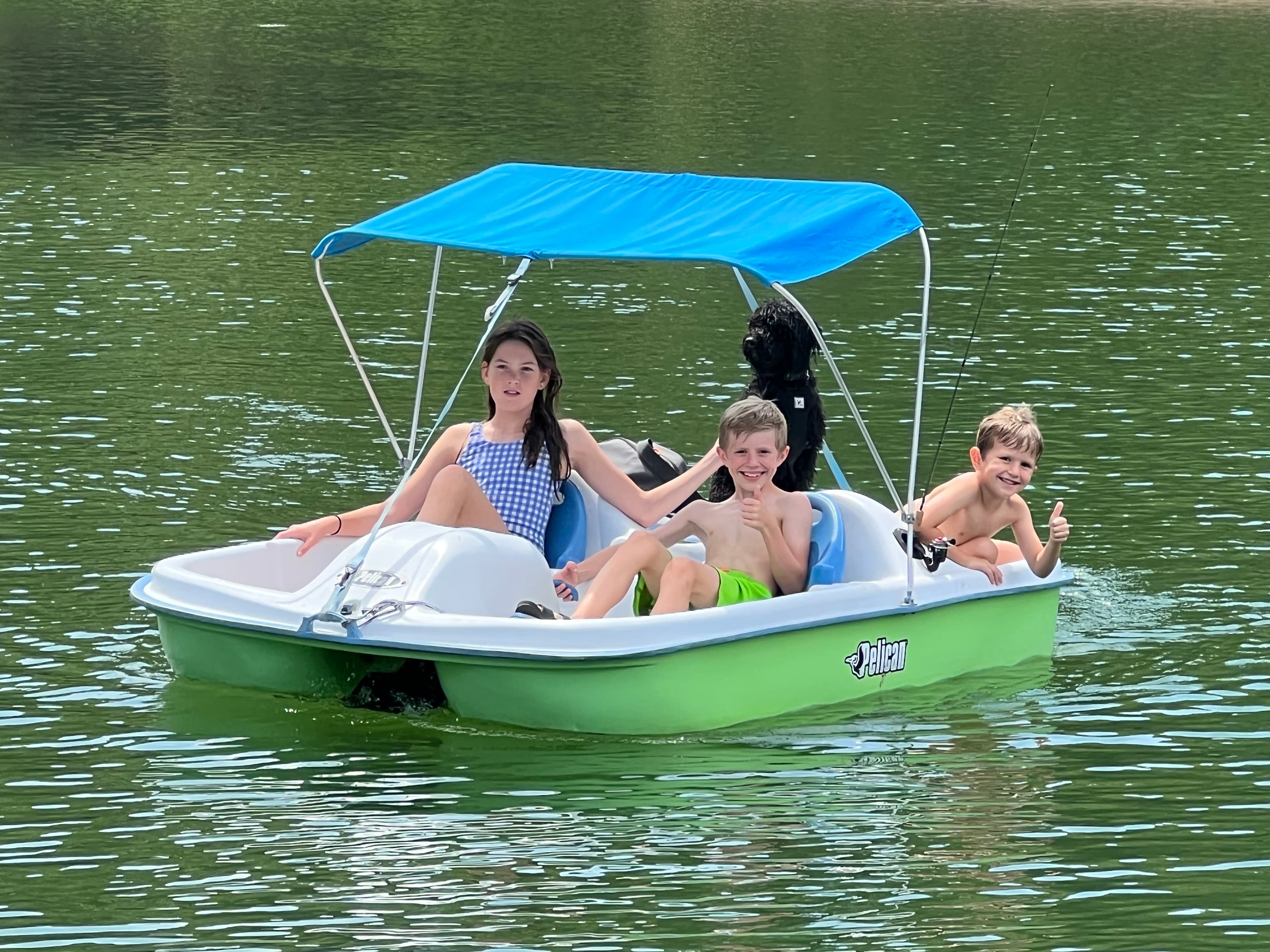 Kids riding a pedal boat on the lake